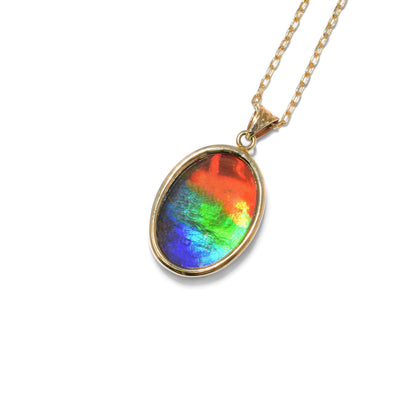 This ammolite pendant is oval in shape and has a triangular bail. The colours of the ammolite include red, yellow, orange, green, light blue, and dark blue.