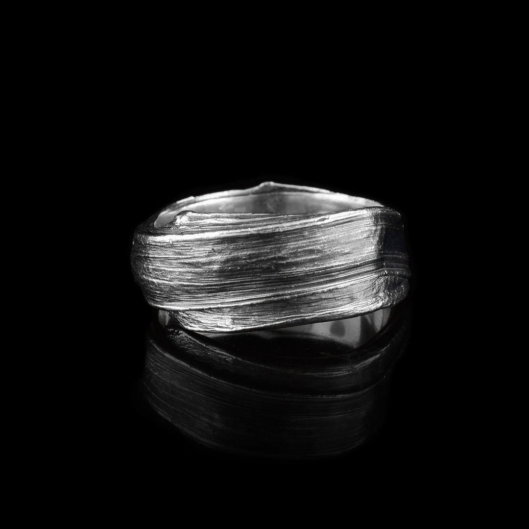 These large sterling silver rings have flowing designs on the surface of it. The piece is made by casting metal into wax so it mimics the appearance of it wax mold. The ring is chunky and has a large gauge.