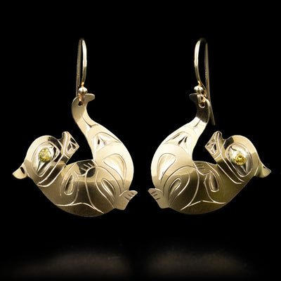These otter earrings are shaped like otters lying on their backs with their tails up. Each otter has a yellow diamond in its eye.