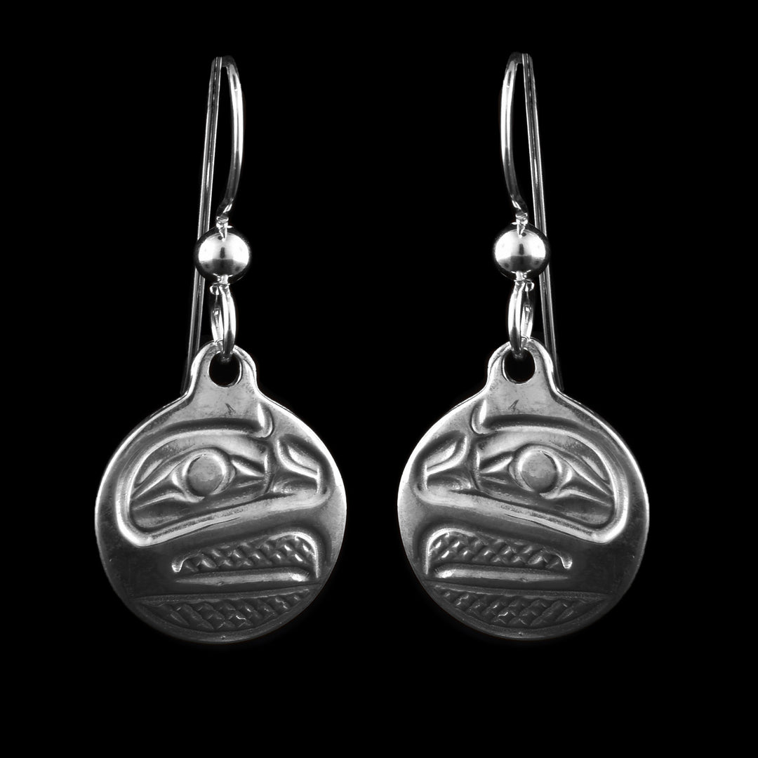 These sterling silver Raven earrings have circle shaped hangs with a depiction of the side profile of he Raven's head cast into the hangs. The eye is large and its beak is open with cross hatching designs made in the background of the scene.