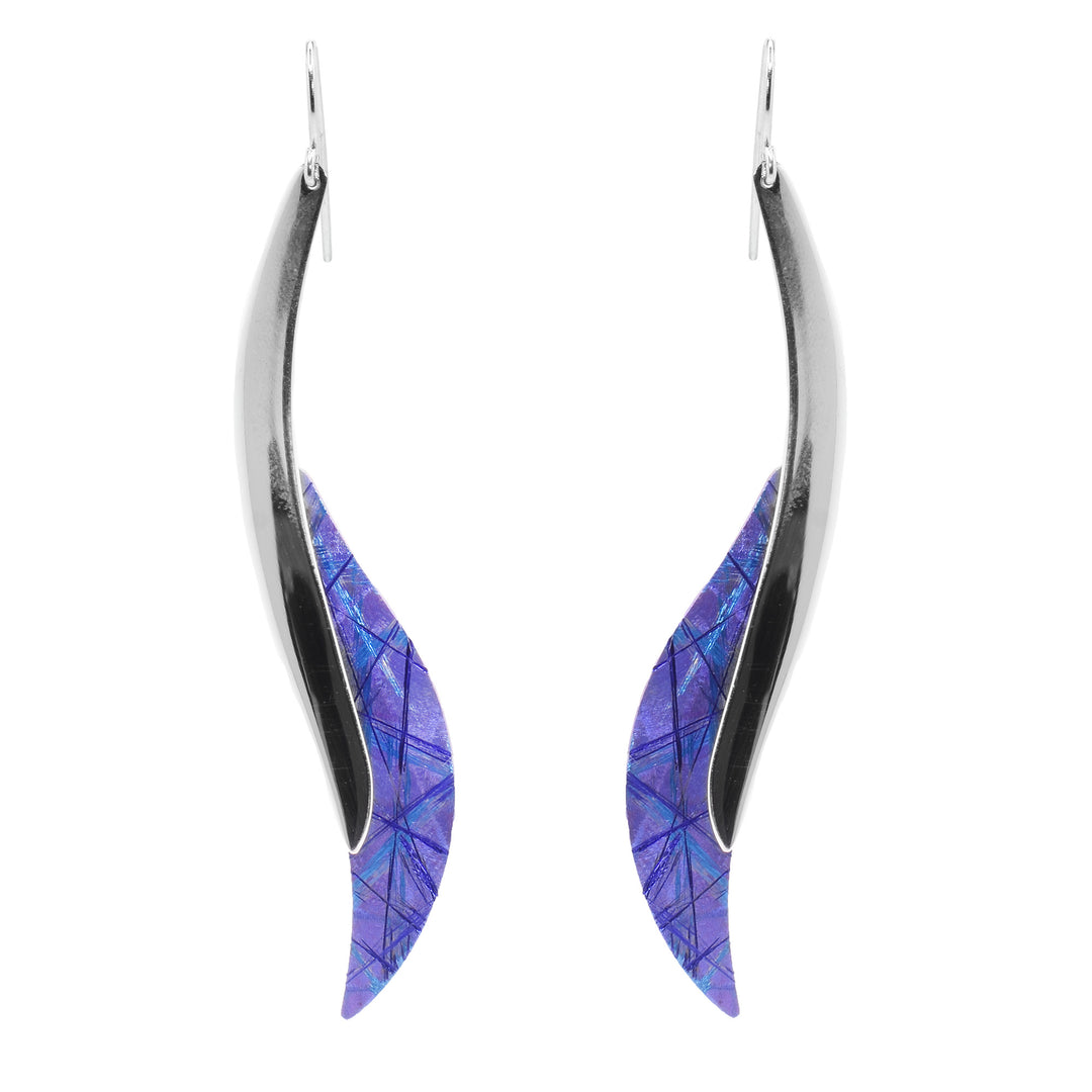 These long titanium drop earrings have wavy hangs with a sterling silver bar and a wider, titanium piece at the bottom. There are purple and blue designs made on the titanium by anodizing it.