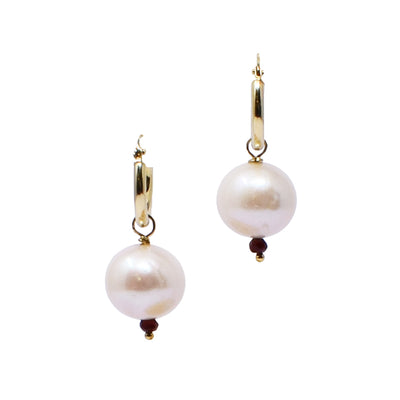 For each earring, there is a 14K gold sleeper hoop with a detachable white freshwater pearl dangling below. A faceted garnet is attached below the pearl.
