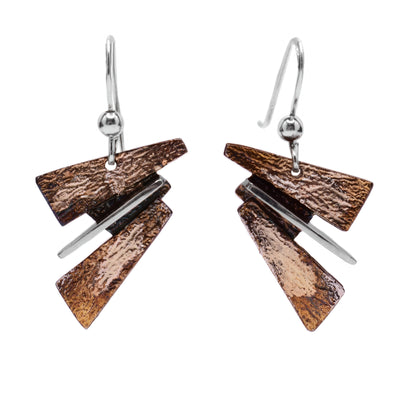These oxidized silver earrings are made up of neutral coloured shapes stacked on top of each other.