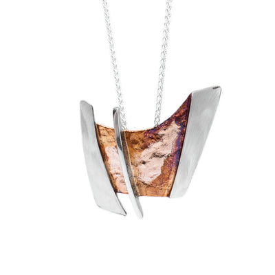 This oxidized silver necklace is an abstract rectangular shape. The middle of the pendant is brown and purple in colour and has 3 sterling silver accents; two on each side and a linear line going through the middle.