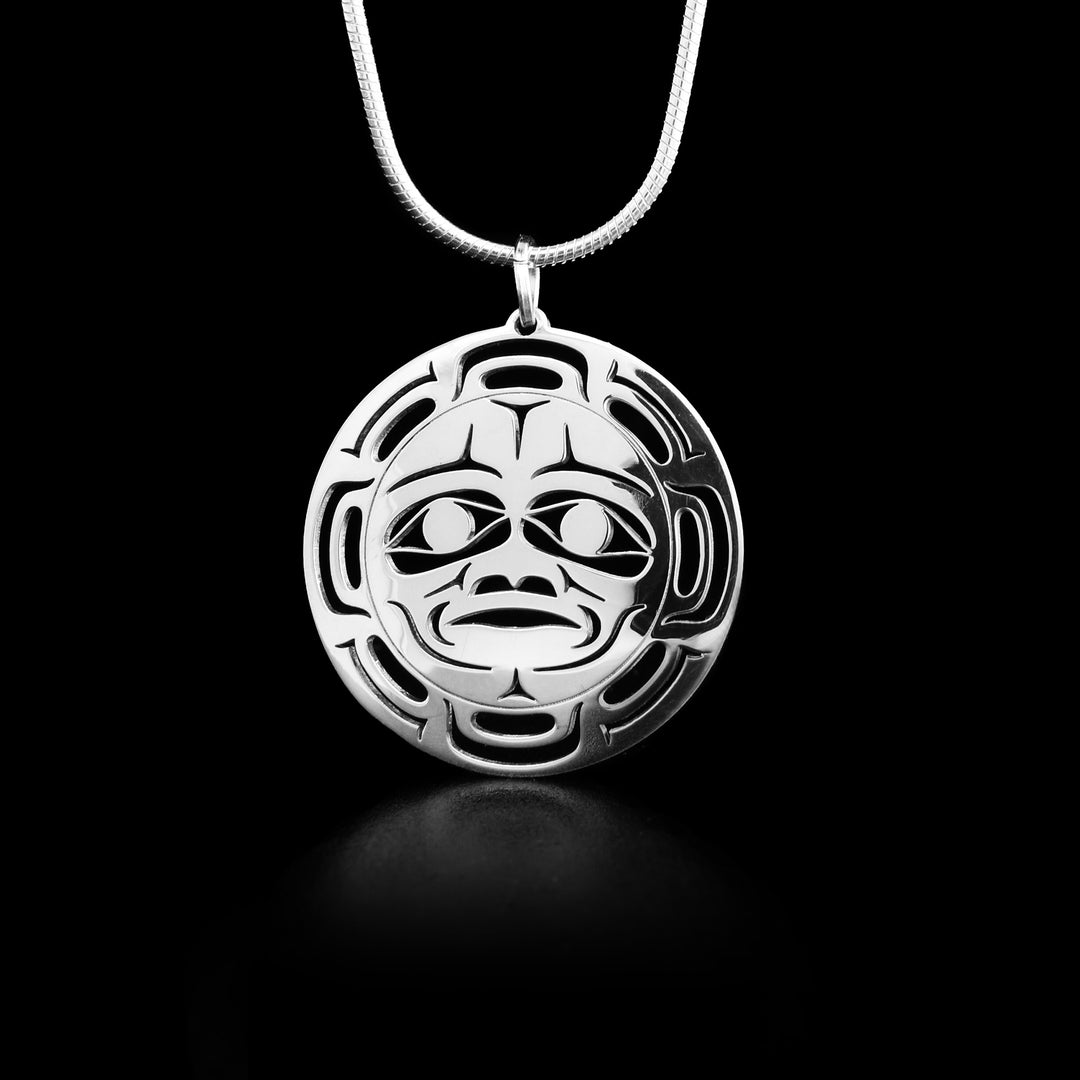 Round sterling silver cut out pendant depicting the Moon. The face of the moon is in the center of the pendant with cut out designs surrounding it depicting the craters on the moon.