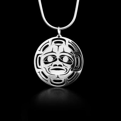 Round sterling silver cut out pendant depicting the Moon. The face of the moon is in the center of the pendant with cut out designs surrounding it depicting the craters on the moon.