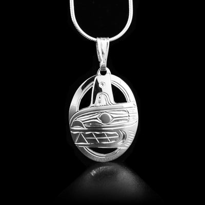 This handcarved sterling silver pendant depicts the Orca's head facing the left with a fin on top. The pendant has an oval shape.