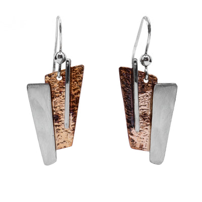 These oxidized silver earrings are rectangular shaped with the base piece being light brown and beige in colour with sterling silver accents attached.