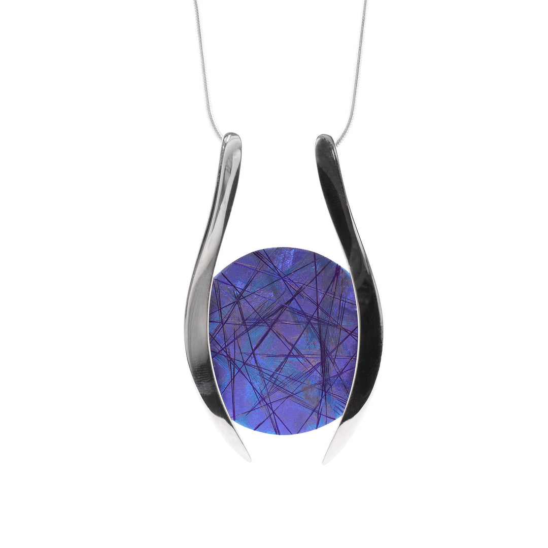 This titanium necklace has a circular piece of blue, purple titanium in the center with two large sterling silver accents on each side encasing it. The chain is attached to both the accents.