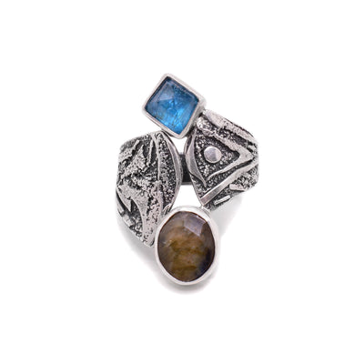This labradorite ring is in a unique shape in which the two ends of the ring meet in the center at the front. The labradorite is an oval shape at the bottom of the ring and the apatite is diamond-shaped at the top of the ring.