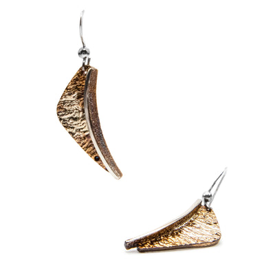 These oxidized silver earrings are wedge-shaped and are orange, light brown in colour with gold accenting.