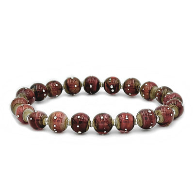 This glass bead bracelet has 20 rose-coloured beads connected on an elastic cord. Each bead has white dots on it.