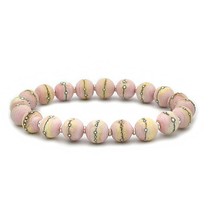 This glass bead bracelet has 20 pink and yellow beads connected on an elastic cord. Each bead has a silver line running through it.