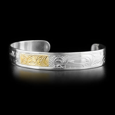 This gold and silver bracelet depicts the heads of two wolves on each side of the bracelet facing towards the center. In the center is a rectangular shape made from gold depicting the phases of the moon; full moon in the middle, half moon on both sides, and crescent moons on the ends.