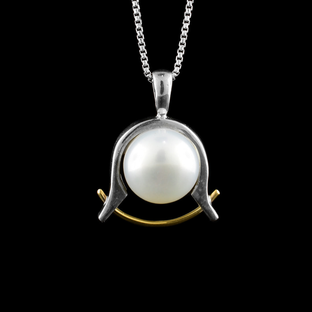 This silver pendant has a sterling silver band holding a fresh water pearl with a rose gold wire underneath it.