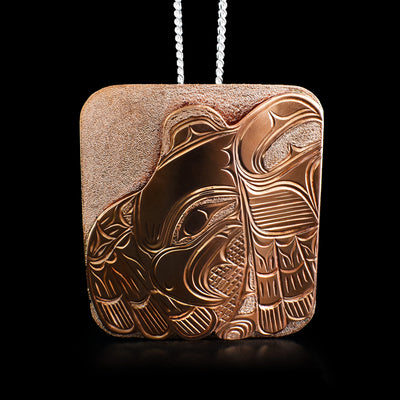 This eagle pendant is rectangular shaped. It depicts an eagle with its wings spread out on the first layer and a hand-carved background as the second layer.