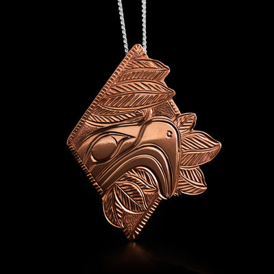 This eagle pendant is diamond-shaped and depicts the face of an eagle coming out of the left corner with leaves around it.