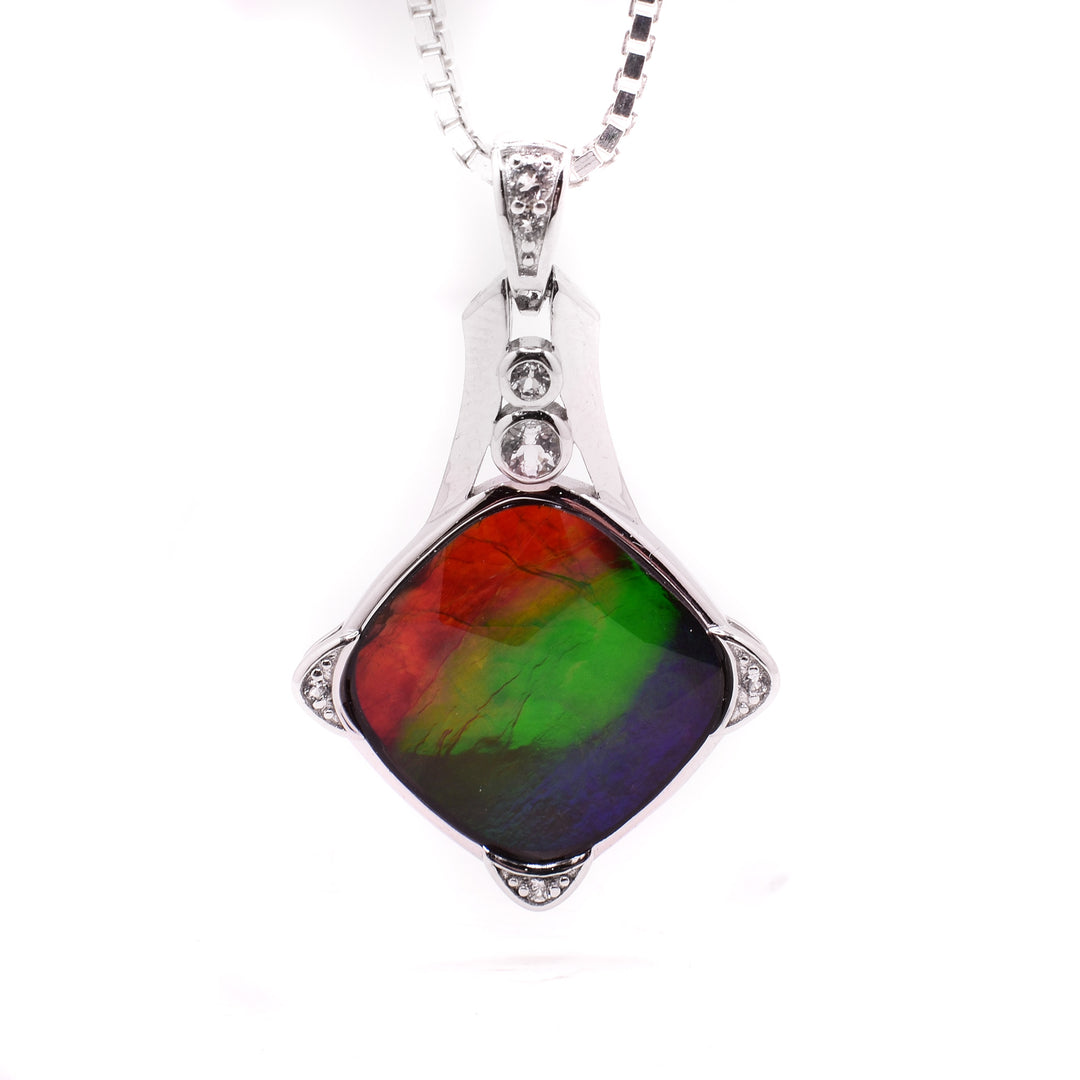 A diamond shaped ammolite pendant with white sapphire details around it.