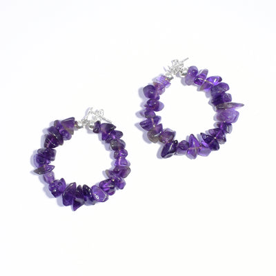 Polished, natural-shaped amethyst beads on hoops. Metal is sterling silver. Circular part of hoop shows when facing side-ways.