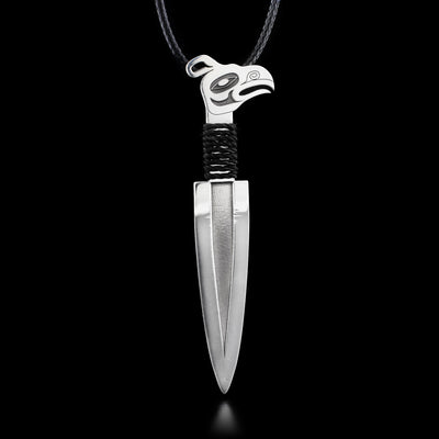 This sterling silver pendant has the shape of a dagger. The top of the dagger handle is shaped like the head of the Thunderbird. Under the Thunderbird, the handle is wrapped in a black chord. The pendant comes with a 16" leather chord that has a 2" extender.