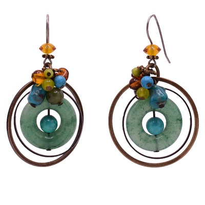 Dangle earrings made of mother of pearl, handworked brass, turquoise, baltic amber, serpentine, aventurine and jade. Titanium ear hooks. By Honica.