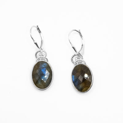 Faceted oval labradorites hang from lever-back hooks. Each earring has two small rope pattern ring adornments above labradorite. Made of sterling silver and labradorite.