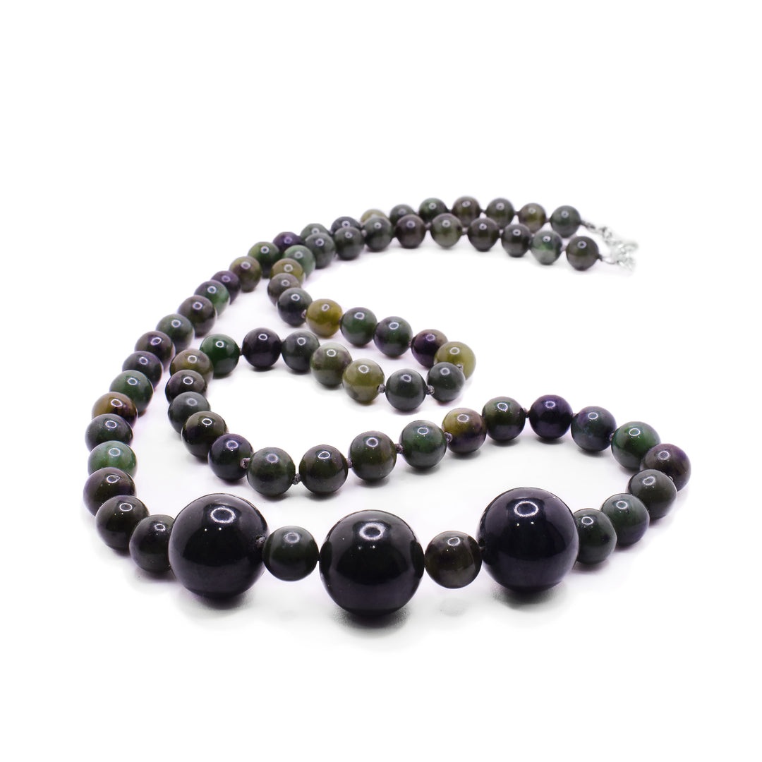 Bold Chunky Jade necklace symbolizing harmony. Features polished dark green and black graduated dark green jade bead necklace. Three darker shades of jades up front surrounded by smaller different shades of jade beads.