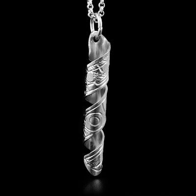 This pendant is made out of a strip of sterling silver that has the face of a Thunderbird and its body handcarved on it. The strip is coiled into a spiral. 