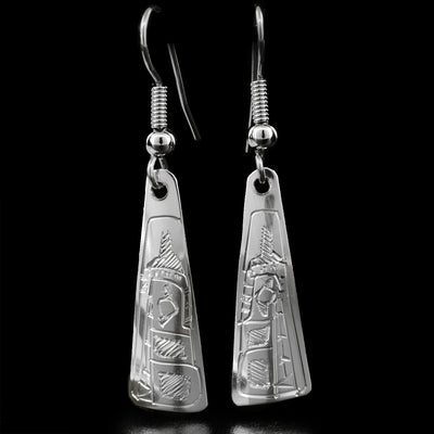 These dangle earrings are made out of sterling silver and are shaped like a long triangle. The Wolf is carved at the bottom of the earrings, and is facing downwards.