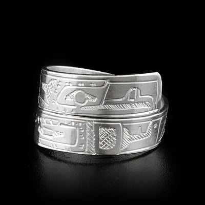 The two ends of this sterling silver wrap ring overlap in the front. One end has the face of the Orca handcarved on it, and the other has the face of the Eagle.