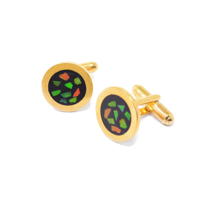 Round yellow gold-plated cufflinks. Faces of cufflinks have gold border and feature mosaic ammolite against a black background. Each cufflink is 0.63” in diameter.
