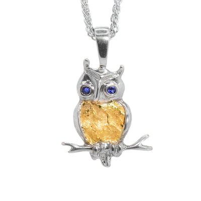 Sterling silver horned owl perched on branch with 22K gold nuggets on belly. Round, faceted blue sapphires set in eyes.