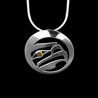 Pendant has a round frame with a laser-cut design of an eagle’s head facing left inside. Solid sterling silver with 18K gold in eagle’s eye.