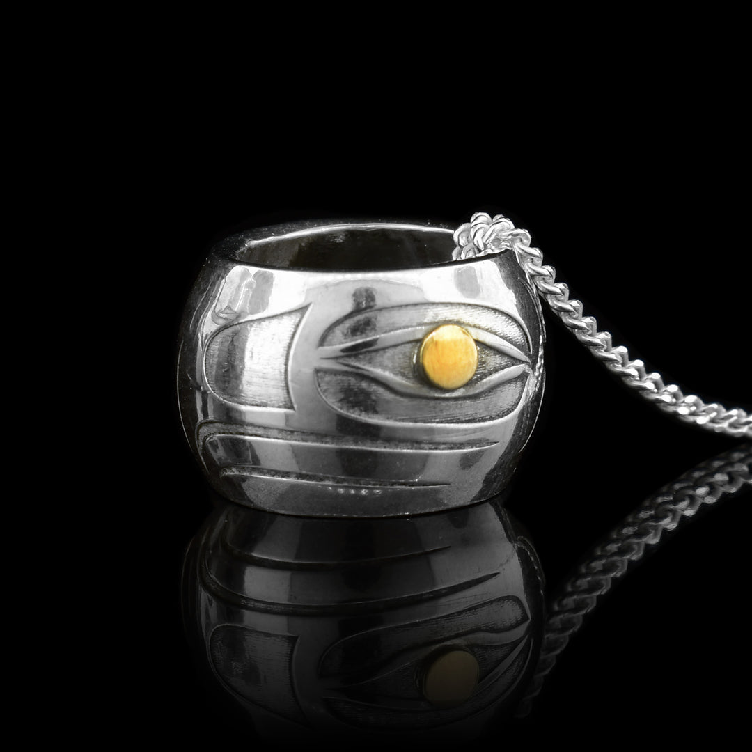 This spirit bead Eagle charm is made from sterling silver and 14K gold. There is a depiction of the Eagle cast into the surface of the bead and the eyes of the legend are made from gold.
