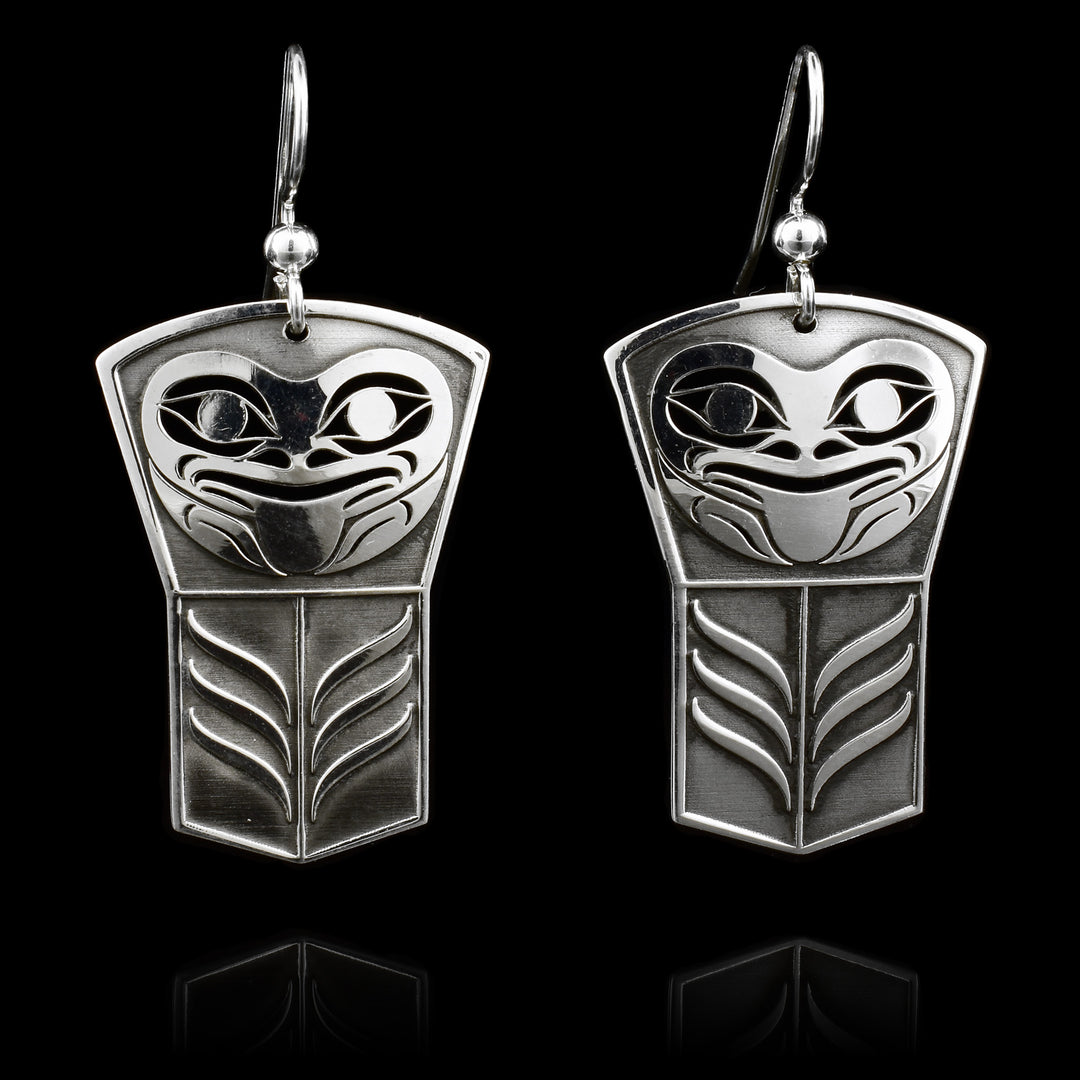 These dangling Frog earrings are made from sterling silver and have large, shield shaped hangs. There are designs cast into the surface of the hangs including a gorgeous depiction of the Frog.