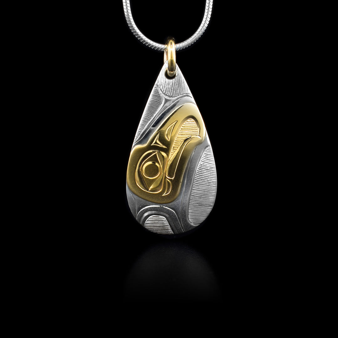 This 14K gold and sterling silver Eagle pendant is teardrop shaped and has a depiction of the Eagle carved into it. The head of the Eagle is made from gold.