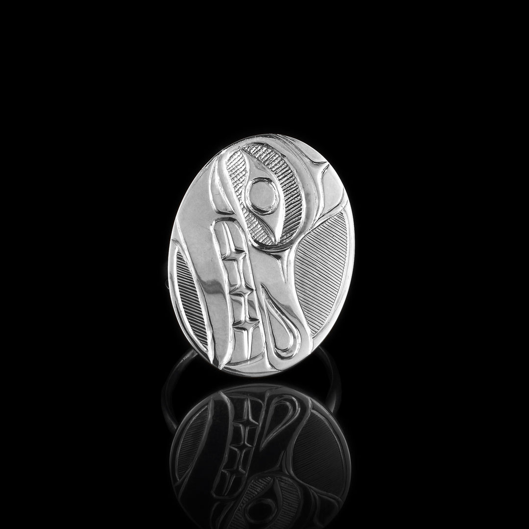 This Wolf signet ring is made from sterling silver and has a thing band. On top of the band is a large, oval signet that has a side profile of the head of the Wolf legend carved into its surface. In the space behind the Wolf, there are fine, hatching details.