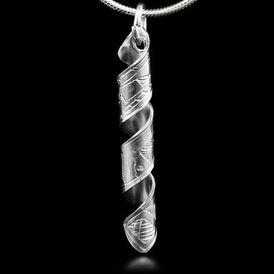 This pendant is made out of a sterling silver strip which has the face and body of the Orca carved on it and then coiled into a spiral.