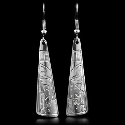 These dangle earrings are carved out of sterling silver. The tringular earrings have a face of the Raven carved on the bottom, looking downward.