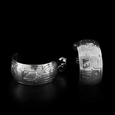These hoop earrings are made out of a flat piece of sterling silver on which a face of the Bear is carved .