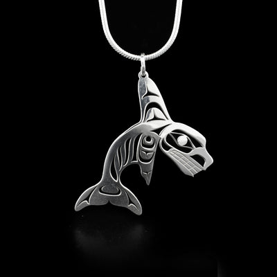 This orca pendant depicts the side-view of a full-bodied orca facing the right. Parts of the orca have been cut out for design and depth.