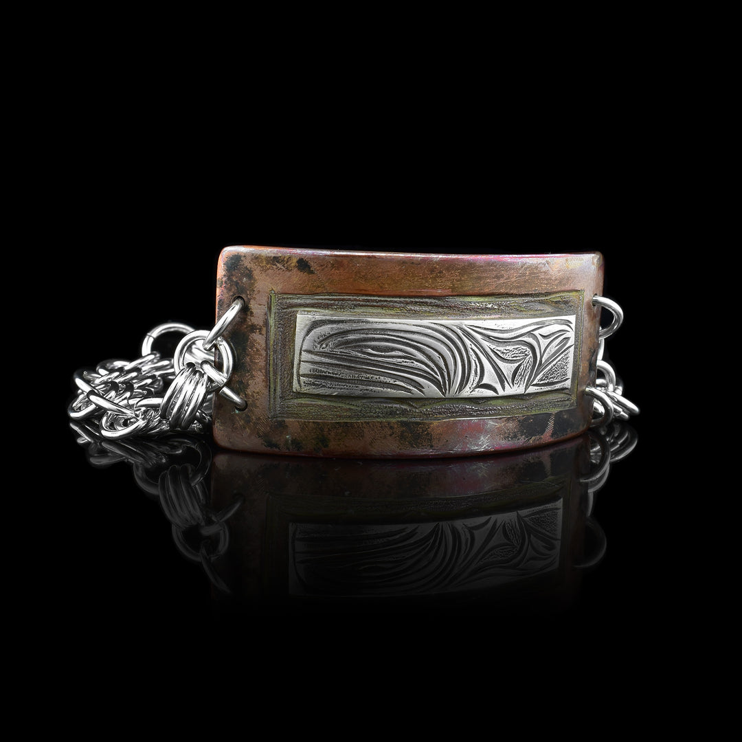 Orca Silver Copper Chain Bracelet the orca is carved in a rectangle of sterling silver imbedded in a copper cuff that's connected with a sterling silver chain.