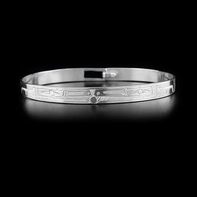 Sterling silver clasp bracelet depicting two ravens facing each other, holding a small ball together between their beaks.