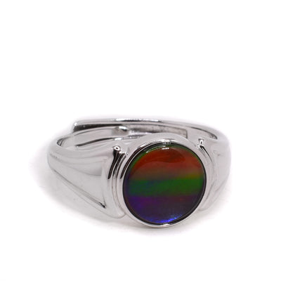 A sterling silver adjustable ring that has a round ammolite stone in the middle.