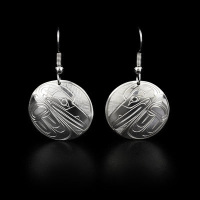 Domed, round sterling silver earrings with ravens facing downwards. Cross-hatching background.