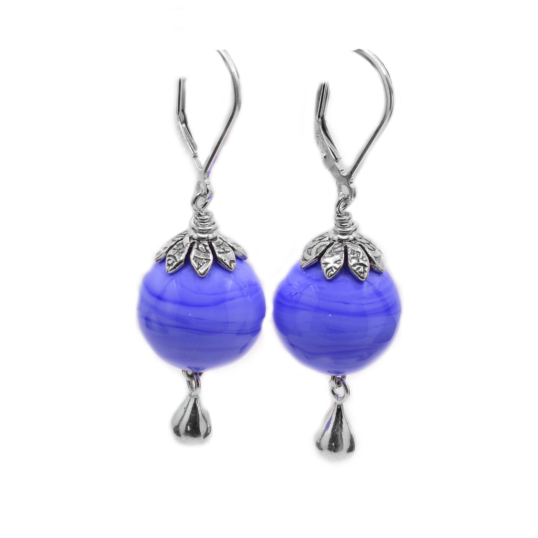 Sterling silver dangle earrings with silver teardrop shapes at bottom. They feature round periwinkle blue lampworked glass beads. Lever back hooks.