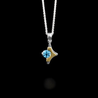 Sterling silver and 14K yellow gold pendant in twinkle shape. Gold layer on top. Blue topaz set in center-right.