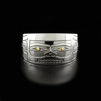 Sterling silver cuff bracelet with tapered ends. Front depicts rectangular 3D face, there is 18K gold in the eyes and design is meant to portray a Chilkat bentwood box.