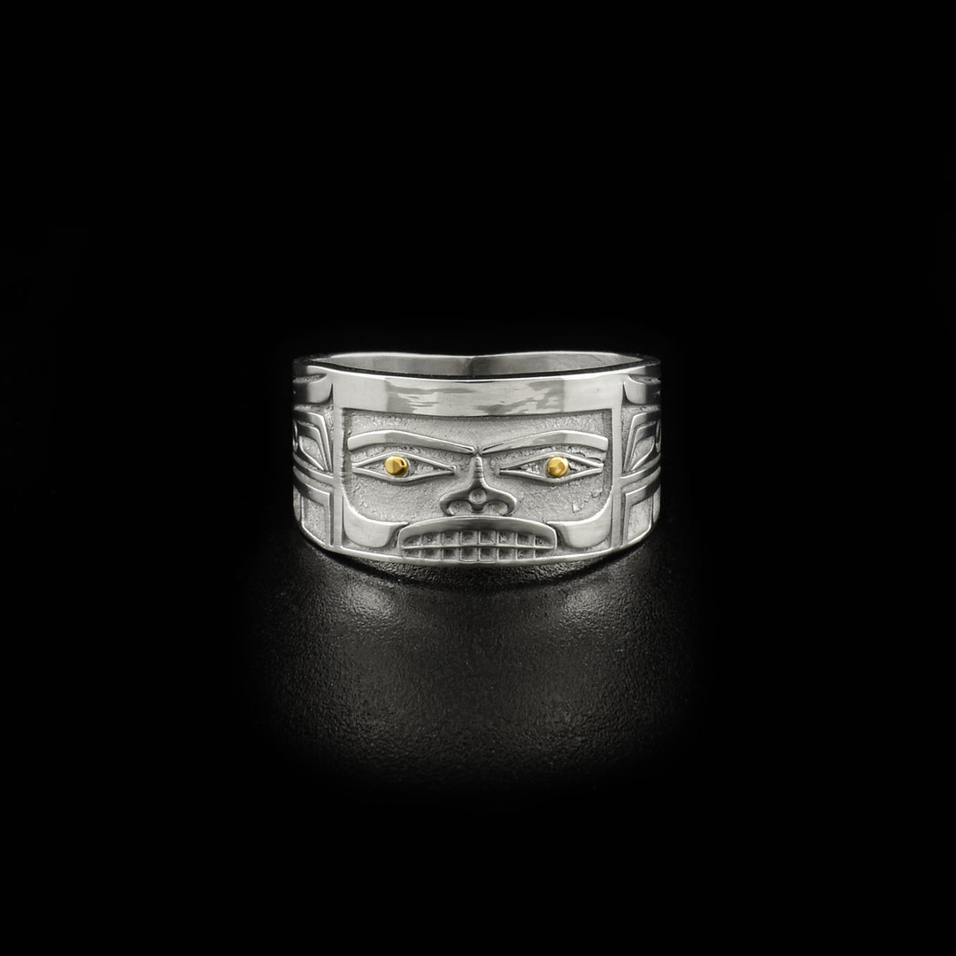 This 14K gold ring is designed to resemble Chilkat bentwood box. Front depicts a face. Pupils are made of 18K gold and rest of ring is sterling silver.