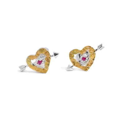 Both earrings are a sterling silver heart with an arrow going through the middle. The heart frame is made of 22K gold nuggets. There is a ruby in the center.